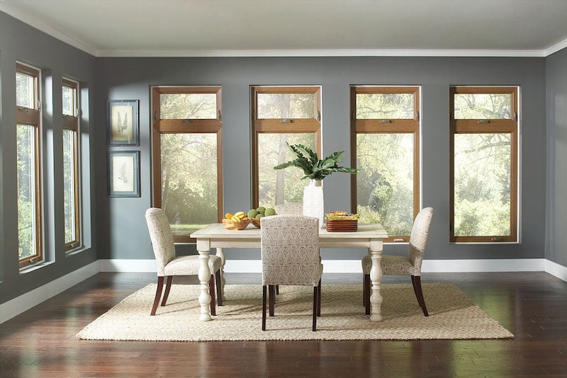 Dining room brightened by natural light from casement windows.