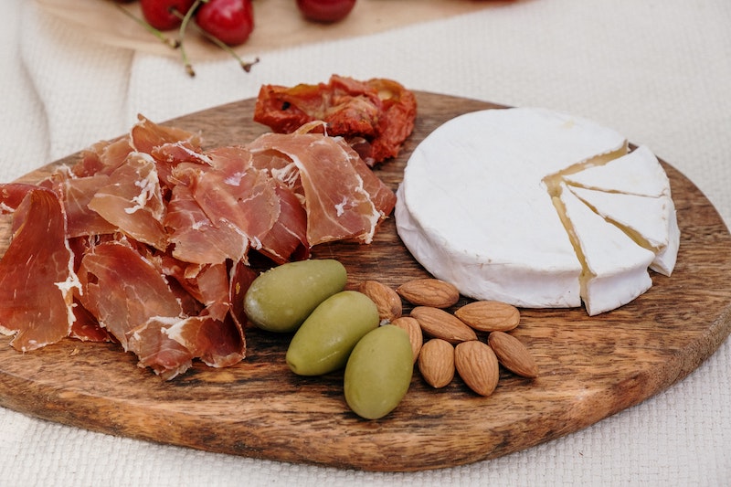 charcuterie board with meat, cheese, and nuts